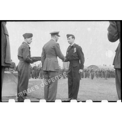 Un pilote du groupe de bombardement Lorraine sert la main à ....... avant de recevoir une décoration.