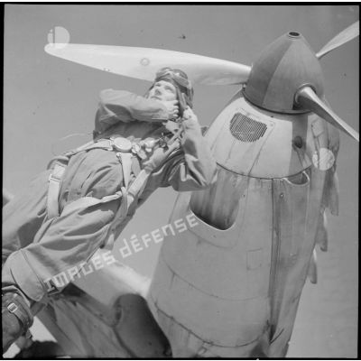 Un pilote du groupe de chasse II/18 Saintonge s'équipe devant son appareil, un Dewoitine D-520.