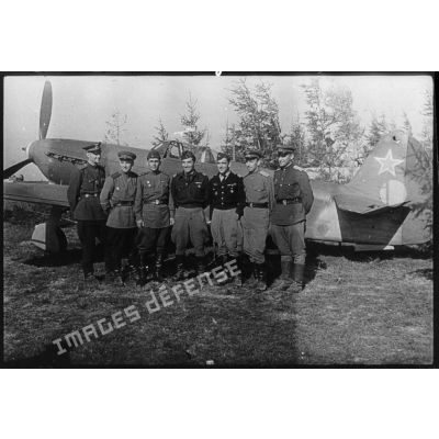 Photographie de groupe du lieutenant-colonel Pierre Pouyade, commandant le régiment de chasse Normandie-Niémen, entouré d'un pilote et de mécaniciens soviétiques.