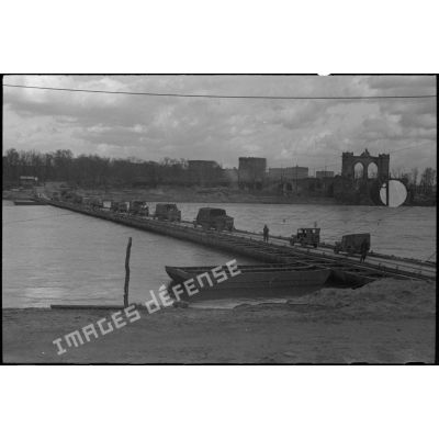 Un convoi emprunte le pont flottant monté sur le Rhin entre Ludwigshafen et Mannheim par le génie américain.