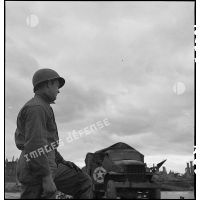 Un soldat américain regarde passer un GMC sur le pont flottant monté par le génie américain entre Mannheim et Ludwigshafen.