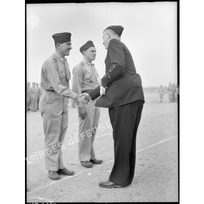 Le général d'armée aérienne Bouscat congratule le sergent-chef Paris qu'il vient de décorer.