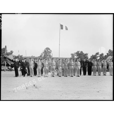 Les autorités militaires saluent le drapeau de la 3e escadre de chasse pendant le défilé.