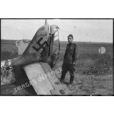 L'ingénieur mécanicien en chef soviétique Sergeï Agavelian, du régiment de chasse Normandie-Niémen, pose devant l'épave d'un appareil allemand Focke Wulf Fw-190 abattu sur le front de l'Est.