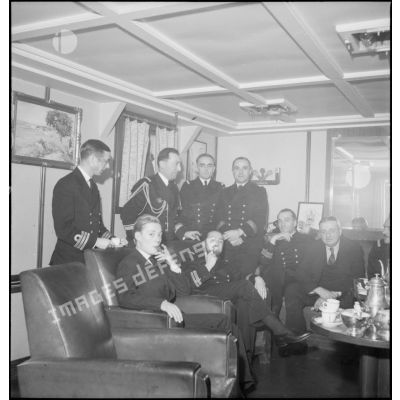 Des journalistes britanniques, en visite à bord du cuirassé Dunkerque, sont reçus dans le carré des officiers supérieurs.
