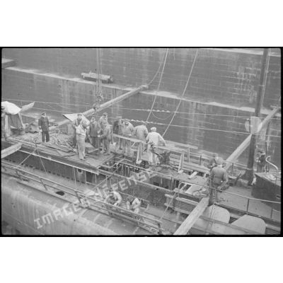 Ouvriers et marins à la maintenance sur le sous-marin mouilleur de mines Saphir, en cale sèche dans un bassin de l'arsenal de Brest.