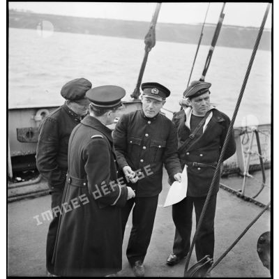 Le commandant du cargo Hélène de la marine marchande danoise, qui vient d'être arraisonné, donne des explications à l'équipage du patrouilleur P 24 Médoc lors de la fouille du cargo.
