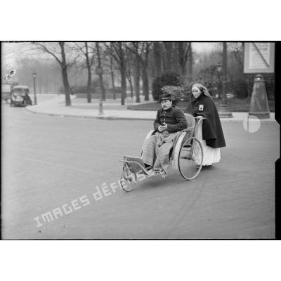 Paris Champs Elysées, infirmière promenant un grand blessé. [légende d’origine]