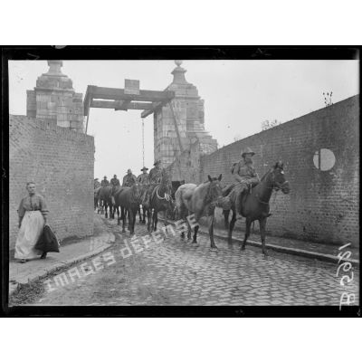 Bergues (Nord). Un détachement de cavaliers australiens traversant le pont levis des anciennes fortifications de la ville. [légende d'origine]