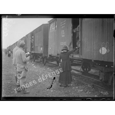 Près Milan. Passage d'un train de troupes françaises. Dame italienne offrant des friandises aux soldats. [légende d'origine]