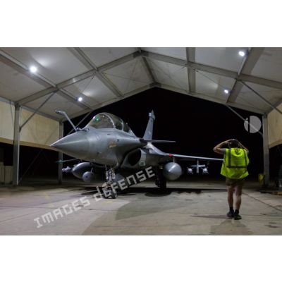 Un mécanicien mène un tour avion autour d'un Rafale au sein d'un hangar de la base aérienne projetée (BAP) en Jordanie.