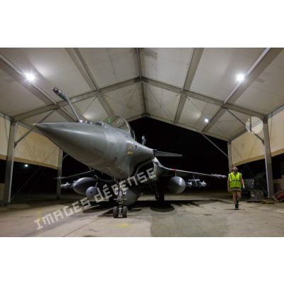 Un mécanicien mène un tour avion autour d'un Rafale au sein d'un hangar de la base aérienne projetée (BAP) en Jordanie.